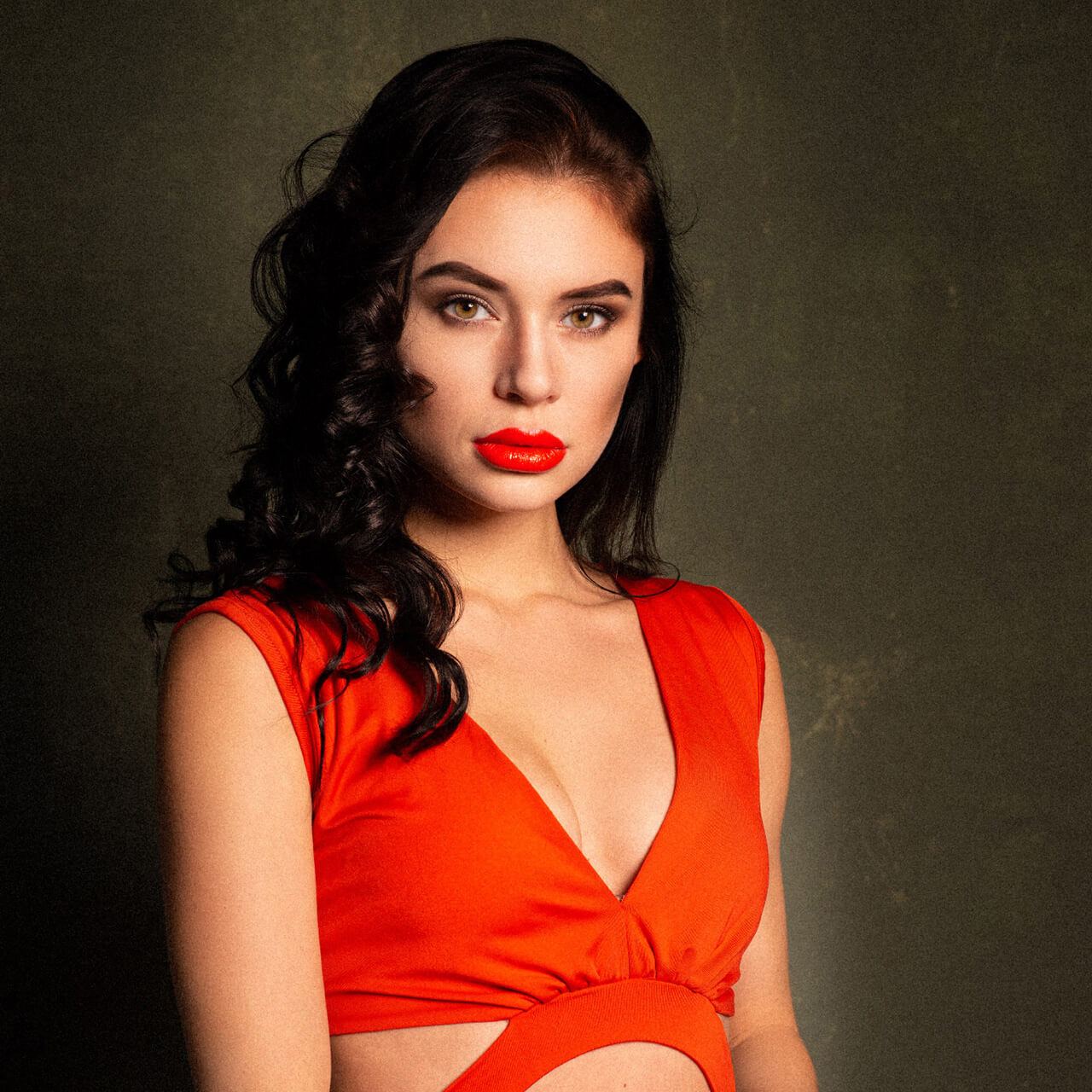 After: Portrait of a dark-haired woman with red lipstick in a red top